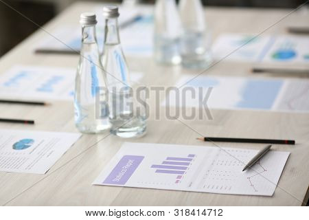 Silver Pen With Business Chart And Drink Water On Seminar Table. Financial Education Concept