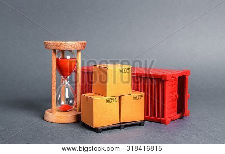 Red Container With Cardboard Boxes And An Hourglass. Express Delivery In Short Time Concept. Tempora