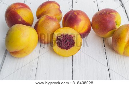 Delicious And Juicy Peach (nectarina) On White Wooden Table With Place For Text.