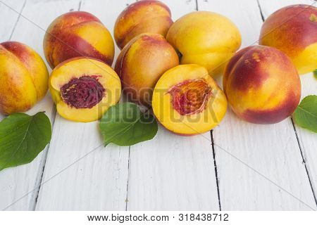 Delicious And Juicy Peach (nectarina) On White Wooden Table With Place For Text.