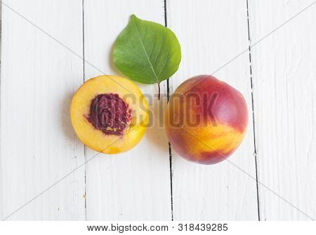 Delicious And Juicy Peach (nectarina) On White Wooden Table With Place For Text.