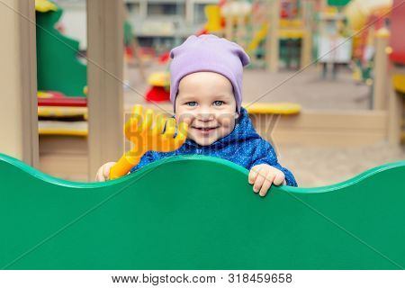 Cute Adorable Caucasian Toddler Boy Enjoy Having Fun At Outdoor Playground. Portrait Of Happy Little