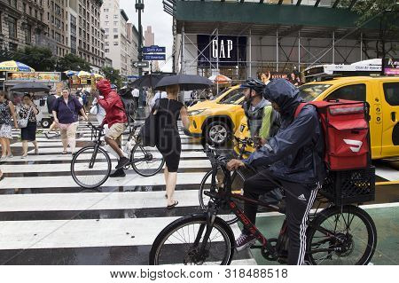 New York, New York/usa - July 22, 2019: Bikers And Autos Wait At 6th Avenue Corner As Pedestrains Cr