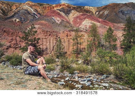 Relaxing man in Valley of Mars landscapes in the Altai Mountains, Kyzyl Chin, Siberia, Russia