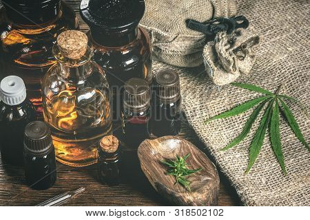 Cbd Oil Bottles And Green Plant Of Cannabis On A Wooden Background. Herbal Medicine.