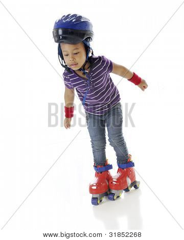 En yndig preschooler usikker på hendes plastic rullens blade.  På en hvid baggrund.