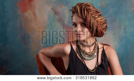 Southern Flavor. Stylish Beautiful Young Woman With Afro Braids Tucked Into A High Hair, Sitting In 