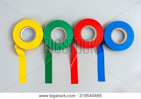 Four Rubber Insulators Of Different Colors On A Gray Background