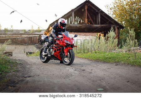 Krasnoyarsk, Russia - August 21, 2019: Beautiful Motorcyclist In Full Gear And Helmet On A Red And B