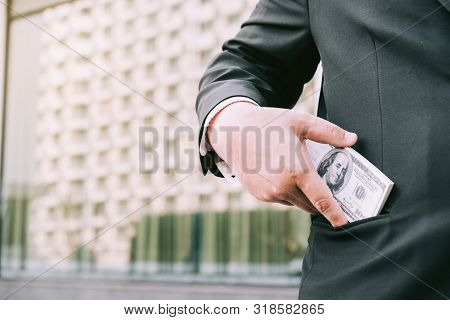 Fat Businessman Putting Money In His Pocket.
