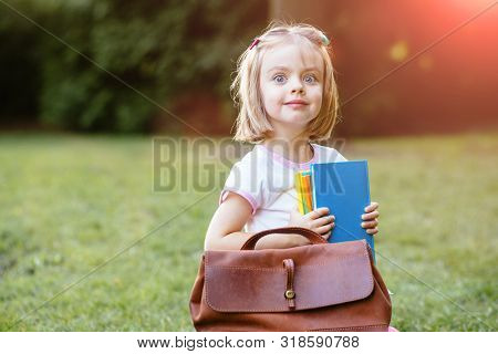 Adorable Happy Little Preschooler Girl With Backpack Ready Back To School, Colorful Textbooks Outdoo