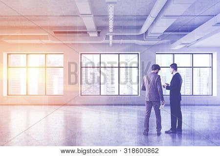Two Businessmen In Empty Industrial Style Office
