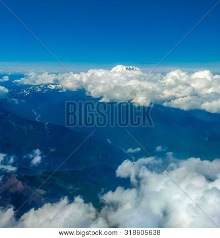 Mount Ranier In Distance Beyond Clouds From Above