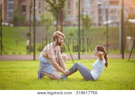 Sit Ups Fitness Couple Exercising Sit Up Outside In Grass. Fit People Working Out Cross Training. Wo