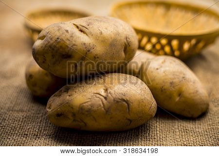 Close Up Shot Of Potato Or Aloo Or Alu On Jute Bag Surface Along With Two Vegetable And Fruit Hamper