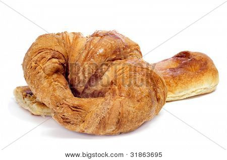 Nærbillede af en croissant og en skive af coca amb sucre på en hvid baggrund