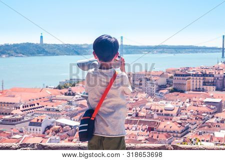 Little Boy Playing With A Binoscope On The Observation Deck Overlooking The Old Town