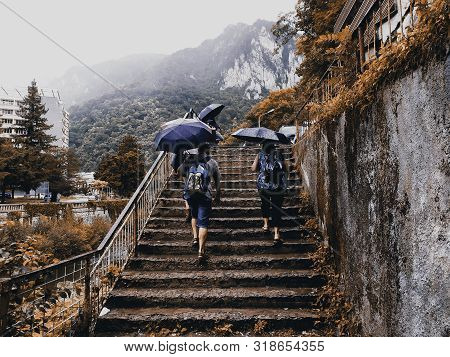 Rainy Travelers With Umbrellas. People Coming Out Of A Subway Station With Umbrellas. A Autumn Lands