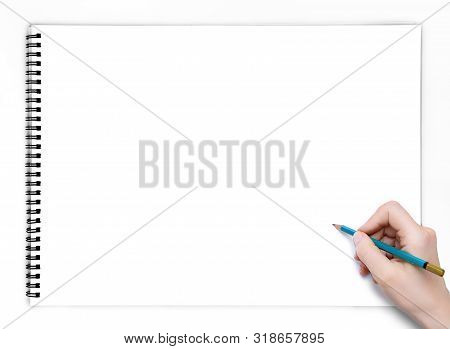 Hand With Pencil In White Blank Sketchpad Book Top View. Copy Space Background.