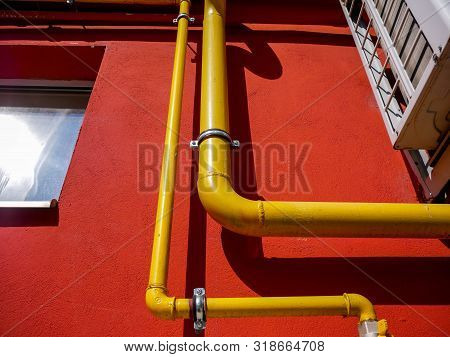 Gas Pipes Close Up Shot On Red Residentual House On Natural Light.