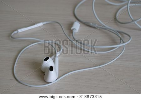 White Modern Headphones On A Light Table In A Sloppy Position