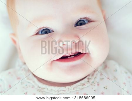 Top View Of Infant Baby Girl, Smilyng With Her First Two Teeth