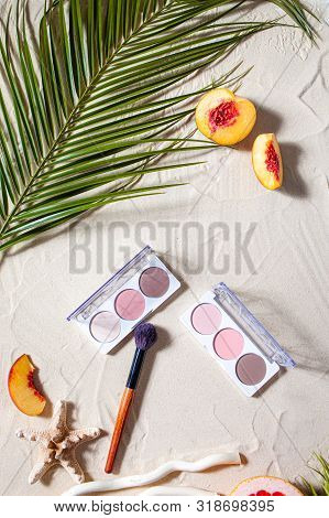 Vacation. A Sculpting Palette And A Blush Brush Lie On The Beach Sand, Surrounded By Vibrant Fruits,