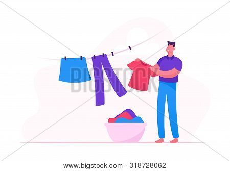 Young Man Hanging Clean Wet Clothes On Rope Taking Washed Linen From Basket In Bathroom Or Laundry. 