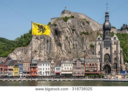 Dinant, Belgium - June 26, 2019: Notre Dame Church And Citadelle From Other River Meuse Bank With Bu