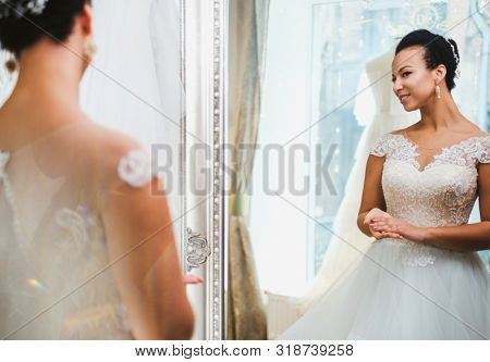 Beautifu bride choosing wedding dress in a wedding salon