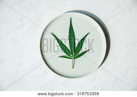 Beautiful Leaf Hemp On A Round Plate. The Concept Of Growing Cannabis For Oil, Medical Purposes.