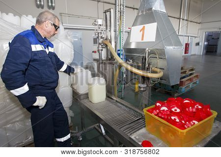 Belarus, The City Of Mensk, April 12, 2019. Chemical Production.a Worker Pours Chemical Liquids Into