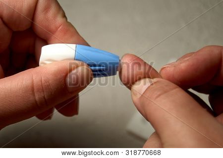 Close Up Of Woman Hands Using Lancet On Finger To Check Hiv Status. Blue Lancet. Hiv Test Express.