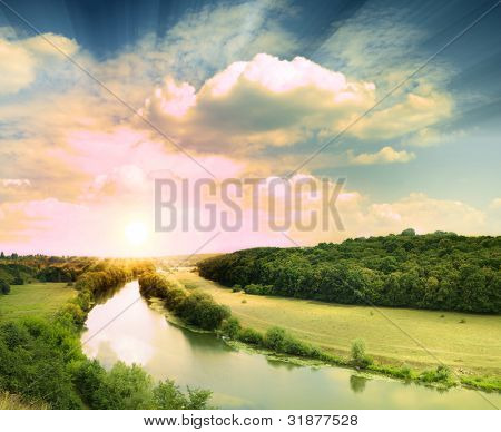Gröna ängen under blå himmel med moln
