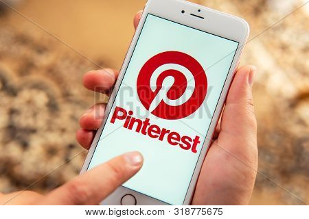 Palo Alto / Usa - August 08 2019: Female Hand With Apple Phone With Logo Of Social Media Pinterest O