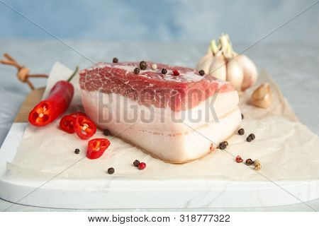 Composition With Pork Fatback And Spices On Board Against Blue Background