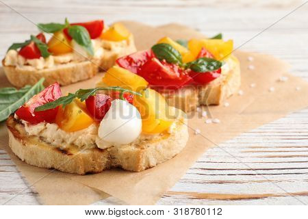 Delicious Tomato Bruschettas On White Wooden Background, Closeup