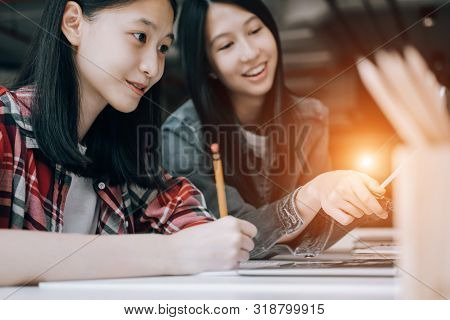 Young Studebt Sitting In Library College Studying And Sharing Knowledge With Laptop Together, Educat