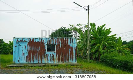 A Blue Were House Are Old. The Wall Of Store Room Have Rusted. The Electricity Is Beside Of Building