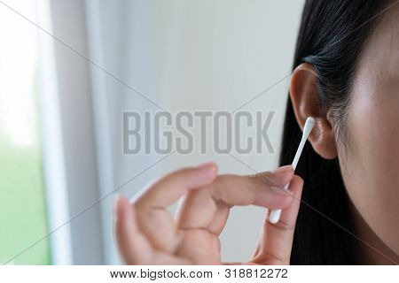 Woman Cleaning Ear With Cotton Swab. Healthcare And Ear Cleaning Concept