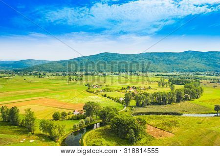 Croatia, Countryside Landscape, Small Village By Gacka River In Region Of Lika, Aerial View