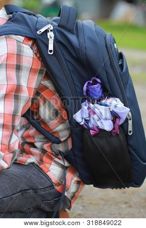 Carrying A School Bag With A Small Umbrella.