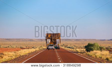 Rear View. Truck Oversize Rides On Road. Large Truck Driven Mining Dumper. Load Ahead
