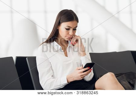 Woman Reading Phone Messages In Airport Waiting Room. Happy Girl Buying E-ticket, Making Hotel Reser