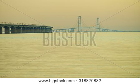 The Bridge Across The Great Belt - The Storebaelt Bridge In Denmark. Two Canoes On Water Surface. Su