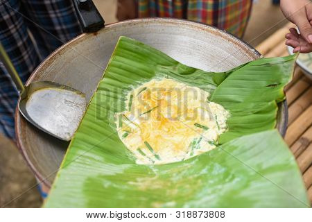 Omelet With Green Onion In A Banana Leaf On Pan Breakfast Asian Food / Khai-pam Fried Egg Omelet Wit