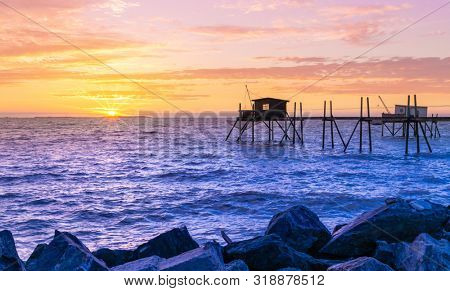 Huts of fishermen in the sunset in Yves bay, France