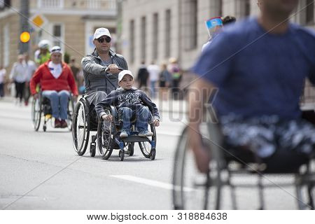 Belarus, The City Of Gimel, July 03, 2019. Youth Festival.wheelchair Race.a Man And A Child In A Whe