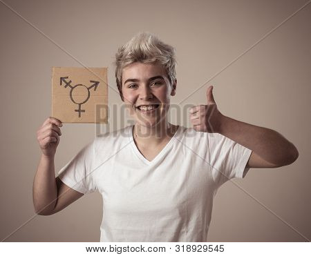 Good Looking Happy And Proud Trans Teenager Holding The Symbol Of The Transgender Drawn On A Cardboa