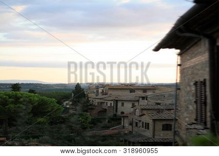 Ancient Tuscan Walled City Houses With Towers And Stone Walls And Paved Cobbled Streets In Italy